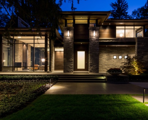 Mississauga home with corner windows, wood siding and frosted glass front door.