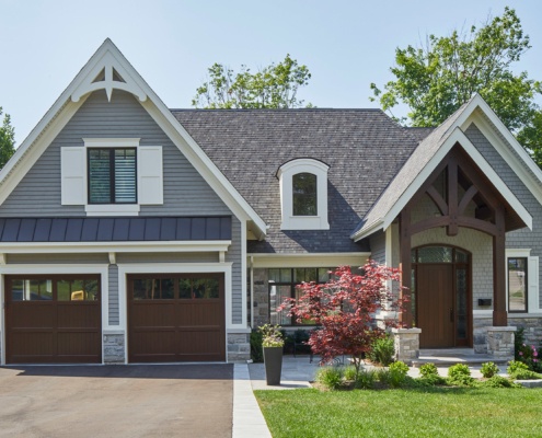Traditional custom home with wood trim, white eaves and stucco siding.