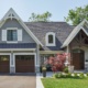 Traditional custom home with wood trim, white eaves and stucco siding.