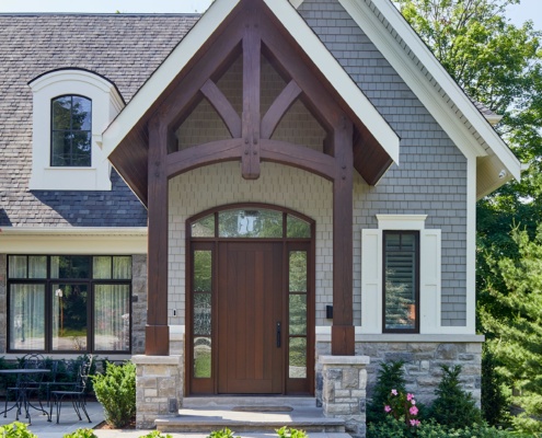 Traditional home with wood portico, stucco siding and natural stone.