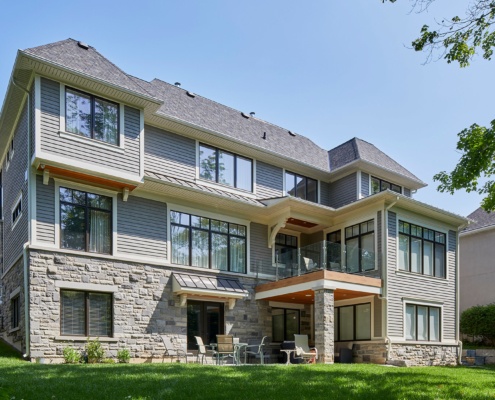 Traditional house with wood siding, white eaves and natural stone.