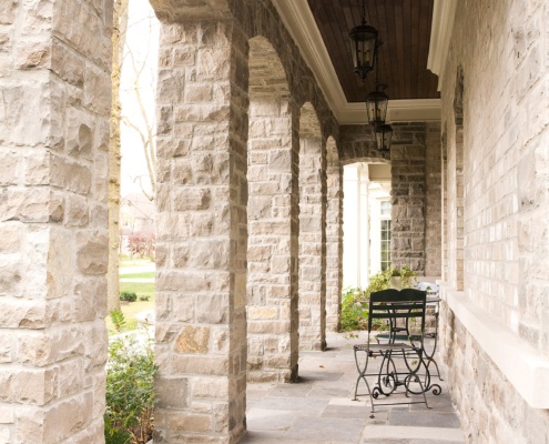 Covered porch with stone columns, stone floor and wood soffit.