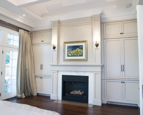 Master bedroom with built in cabinets, marble fireplace and crown moulding.