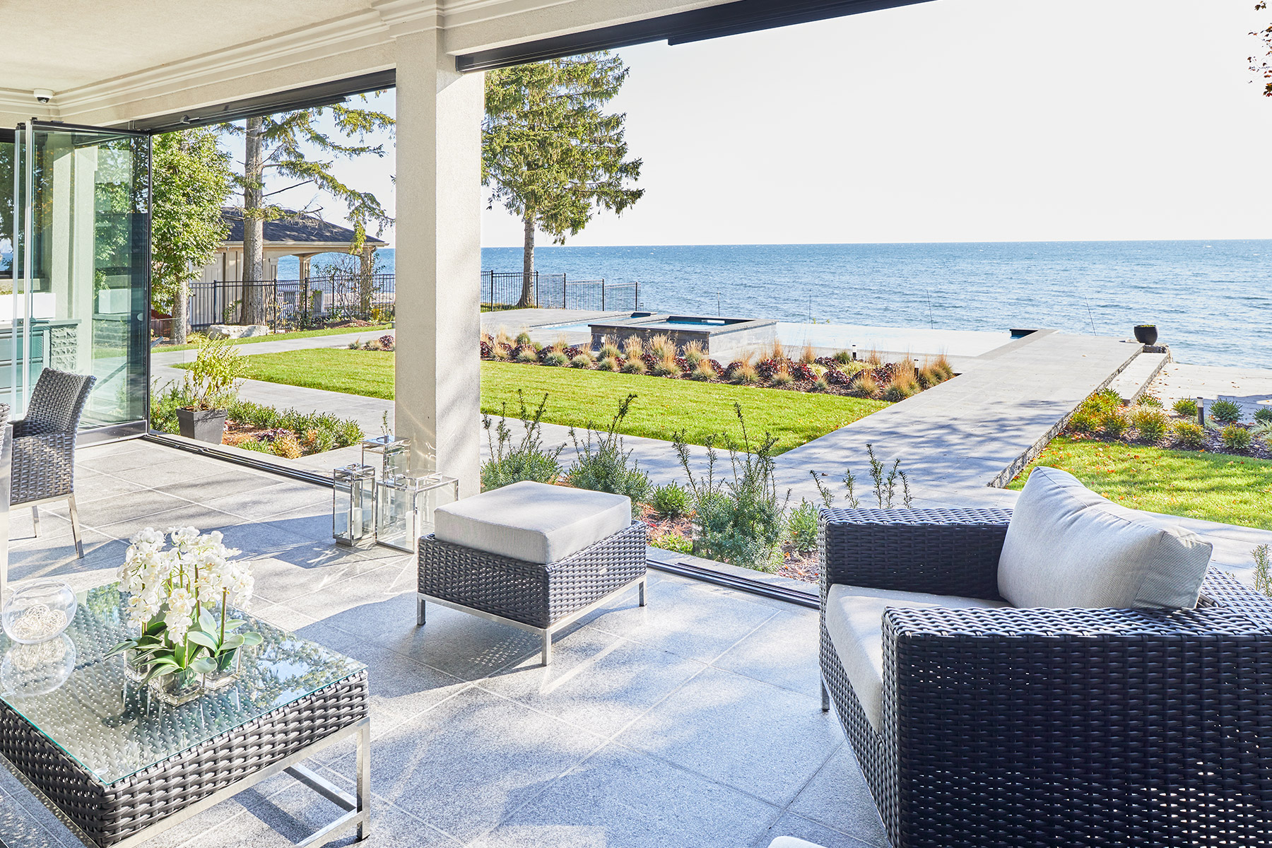 Stone covered patio with stucco columns and lakefront view.