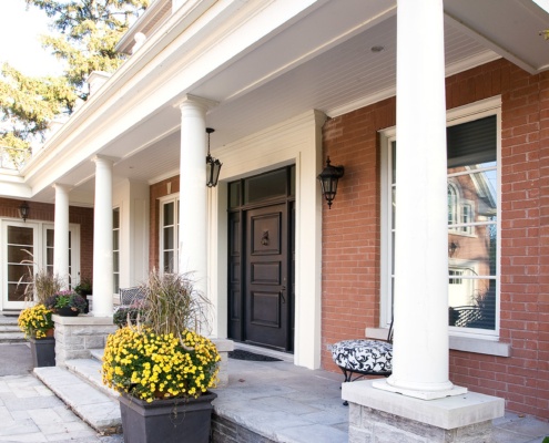 Traditional house with white columns, stone porch and white trim.