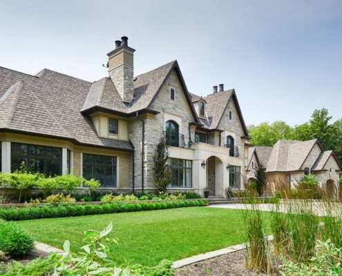 Traditional home exterior with natural stone, brick and black frame windows.