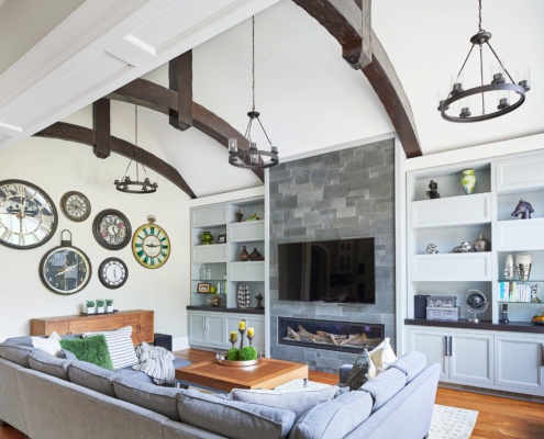 Cozy living room with stone fireplace, built in shelves and hardwood floor.