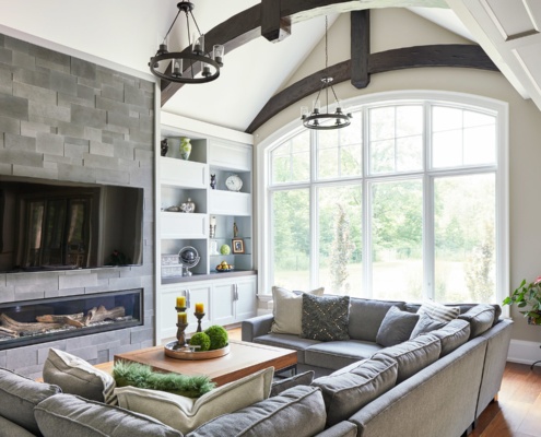 Traditional family room with wood beam, stone wall and arched window.