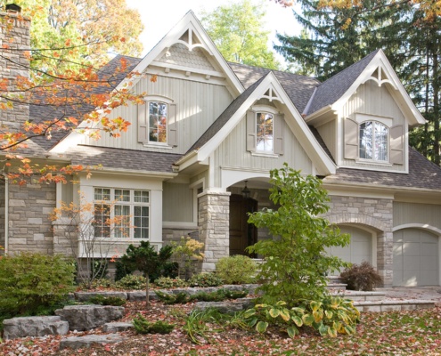 Traditional home with arched windows, wood siding and vertical siding.