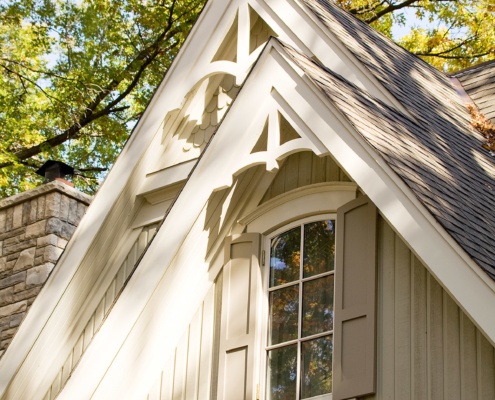 Mineola house with gabled roof, beige shutters and white trim.