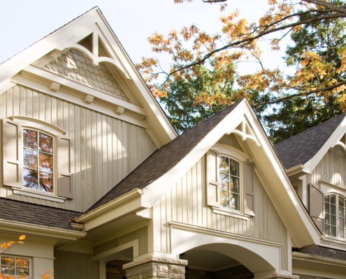 Traditional house design with gables, shutters and covered entry.