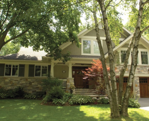 Mississauga renovation with wood garage door, natural stone and white trim.