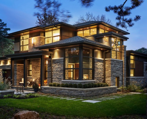Exterior of modern house with horizontal stone, metal cladding and black trim.