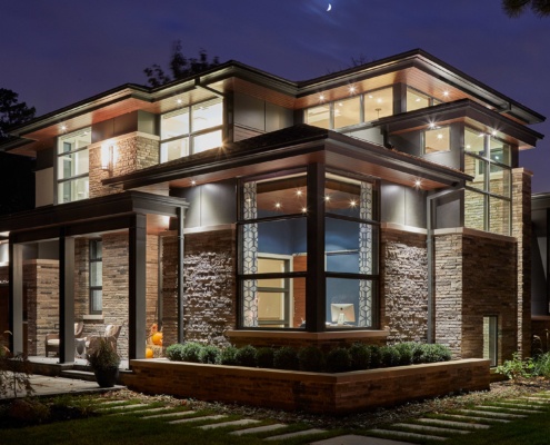 Natural modern home with corner window, floating roof and wall sconce.