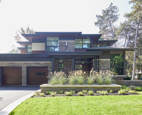 Contemporary home with stucco siding, stone planters and wood soffit.