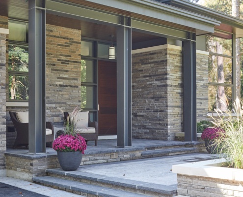 Modern home with steel beam, wood soffit and natural stone siding.