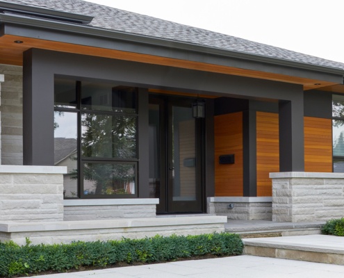 Contemporary home with wood siding, black frame window and covered porch.