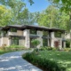 New custom home with stucco siding, dark trim and circular driveway.