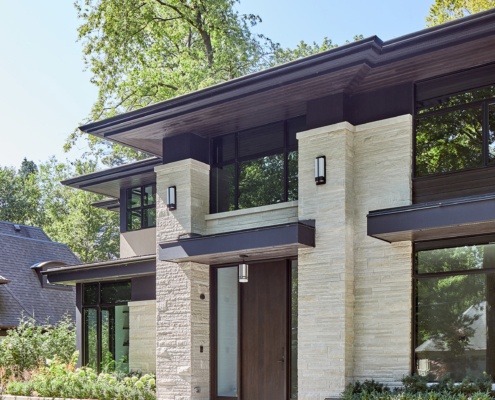 Contemporary house exterior with wood soffit, large roof overhang and wall sconces.
