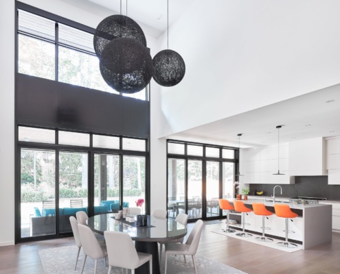 Contemporary kitchen with white cabinets, gray backsplash and white island.