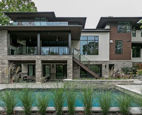 Modern home with natural stone, stucco siding and floating roof.