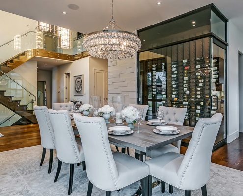 Formal dining room with wood table, chandelier and wine storage.