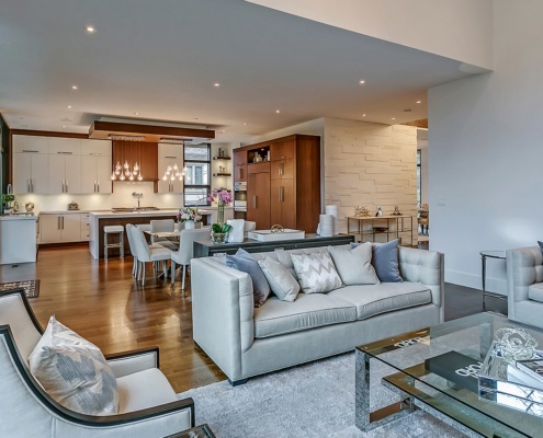 Living room with hardwood floor, white baseboard and floor to ceiling windows.