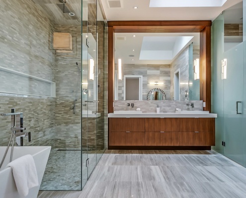 Large bathroom with tile floor, glass shower and floating vanity.
