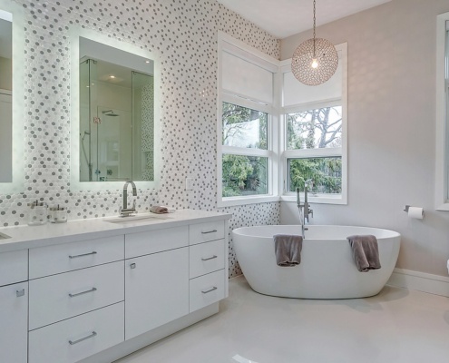 Master bathroom with tile wall, corner window and freestanding tub.