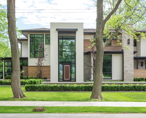 Ultra modern home with floor to ceiling windows, wood siding and wood shingles.