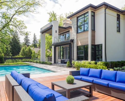 Home exterior with stucco siding, floating roof and wood soffit.