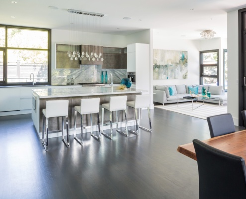 Custom kitchen with white countertops, white trim and wood floor.