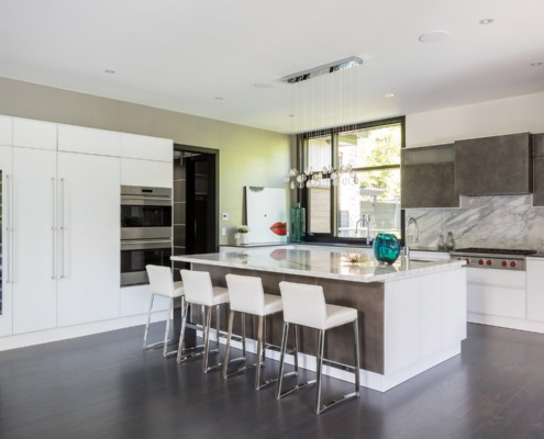 Contemporary kitchen with dark cabinets, pendant lights and hardwood floor.
