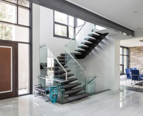 Custom home with wood front door, white trim and contemporary dining room.