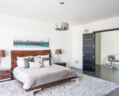 Master bedroom with double doors, dark floor and shag carpet.