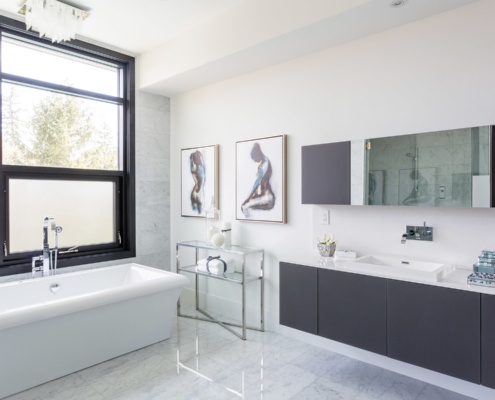 Master bathroom with black frame windows, floating vanity and white trim.