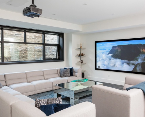 Home theater with white baseboard, black frame windows and projector.