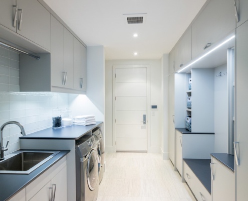 Laundry with tile floor, cubby and white trim.