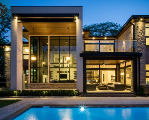 Modern home with covered porch, wood soffit and floor to ceiling windows.