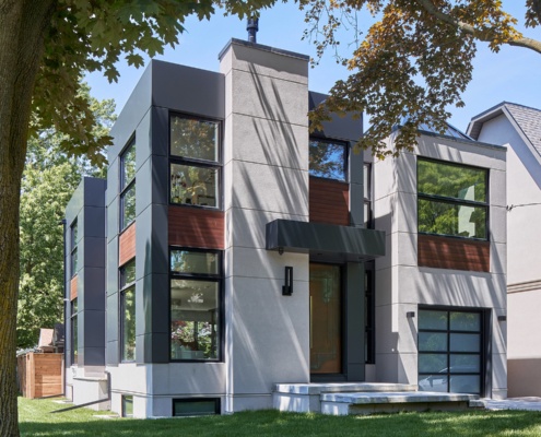 Contemporary house design with metal roof, frosted glass garage door and wood siding.