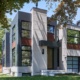 Contemporary house design with metal roof, frosted glass garage door and wood siding.