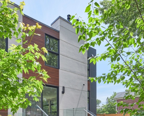 Modern house with wood siding, stucco siding and glass railing.