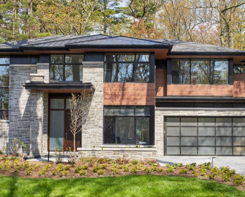 Contemporary house design with metal roof, horizontal siding and black frame windows.