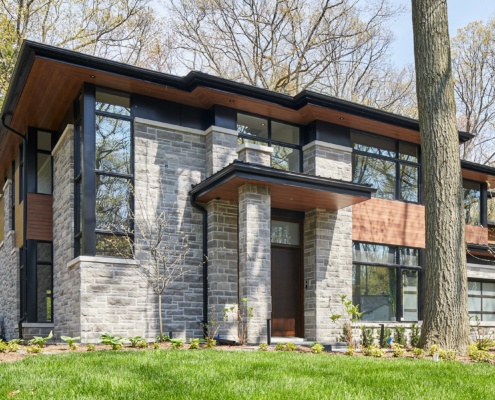 Mississauga house with wood front door, black cladding and wood soffit.