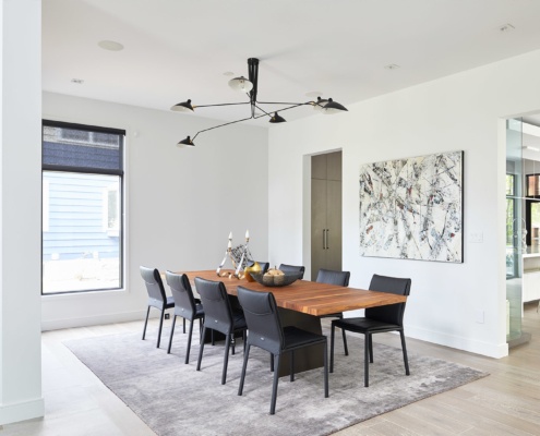 Contemporary dining room with hardwood floor, wood dining table and modern chandelier.