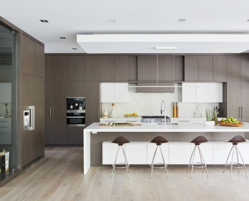 Kitchen with breakfast bar, white countertop and dark cabinets.