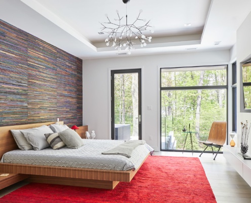 Contemporary master bedroom with floating bed, black frame windows and wallpaper.