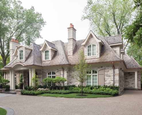 Traditional home with natural stone, shutters and two chimneys.