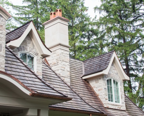 Custom home with stone chimney, arched window and stone siding.