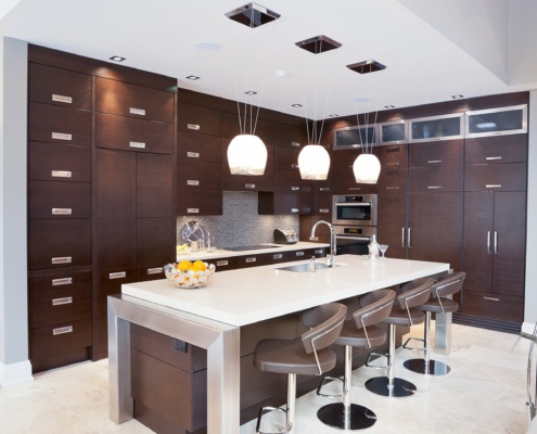 Wood kitchen with white island, tile backsplash and pendant lighting.